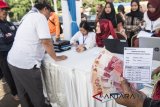 Warga menunjukan uang sebelum ditukarkan di loket mobil kas keliling saat pembukaan layanan penukaran uang di Bandung, Jawa Barat, Senin (21/5). Bank Indonesia Kantor Perwakilan Wilayah Jawa Barat memproyeksikan kebutuhan uang Ramadan tahun 2018 berjumlah Rp11,92 triliun, meningkat sebesar Rp440 miliar atau 3,8 persen dibandingkan realisasi pemenuhan kebutuhan Ramadan tahun lalu sebesar Rp11,48 triliun. ANTARA JABAR/M Agung Rajasa/agr/18
