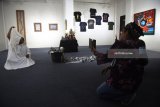 Pengunjung mengamati karya seni yang ditampilkan pada pameran yang bertajuk Molimo di Taman Budaya Jawa Timur, Surabaya, Jawa Timur, Kamis (24/5). Pameran yang digelar seniman yang tergabung dalam komunitas seni Museum of Mind tersebut dalam rangka menyambut ulang tahun kota Surabaya ke-725. Antara Jatim/Zabur Karuru/18