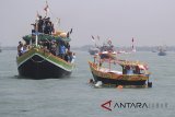 Sejumlah warga menaiki perahu rajungan Saat mengikuti nadran rajungan di karangsong, Indramayu, Jawa Barat, Rabu (2/5). Nadran (pesta laut) nelayan rajungan merupakan ungkapan rasa syukur nelayan atas hasil tangkapan rajungan dan keselamatan ketika melaut dengan membuang ketengah laut kepala kerbau sebagai sesaji. ANTARA JABAR/Dedhez Anggara/agr/18.