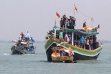 Sejumlah warga menaiki perahu rajungan saat mengikuti nadran rajungan di karangsong, Indramayu, Jawa Barat, Rabu (2/5/2018). Nadran (pesta laut) nelayan rajungan merupakan ungkapan rasa syukur nelayan atas hasil tangkapan rajungan dan keselamatan ketika melaut dengan membuang ke tengah laut kepala kerbau sebagai sesaji. (ANTARA FOTO/Dedhez Anggara) 