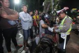 Polisi memeriksa isi barang bawaan pengguna motor yang terjaring razia cipta kondisi di Jalan Darmo, Surabaya, Jawa Timur, Sabtu (26/5) malam. Operasi yang digelar Polrestabes Surabaya itu memeriksa kelengkapan surat kendaraan bermotor dan barang bawaannya guna mengantisipasi peredaran minuman keras, narkoba, senjata tajam atau bahan-bahan berbahaya serta untuk memberikan rasa aman kepada masyarakat. Antara Jatim/Didik Suhartono/zk/18