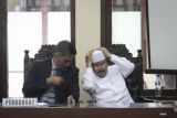 Juru Bicara Hizbut Tahrir Indonesia (HTI) Ismail Yusanto (kanan) mengikuti sidang pembacaan putusan di Pengadilan Tata Usaha Negara (PTUN), Jakarta, Senin (7/5/2018). Majelis Hakim PTUN menolak gugatan yang diajukan HTI karena menilai surat keputusan Kementerian Hukum dan Hak Asasi Manusia (Kemenkumham) yang mencabut status badan hukum HTI sudah sesuai dengan prosedur. (ANTARA /Dhemas Reviyanto) 