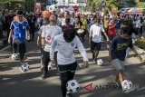 Warga menunjukkan aksi dribel bola saat parade Piala Dunia 2018  di Car Free Day Dago, Bandung, Jawa Barat, Minggu (13/5). Parade tersebut dilakukan guna mensosialisasikan event sepakbola Piala Dunia 2018 di Rusia serta hak siar yang dipegang oleh salah satu stasiun TV Swasta di Indonesia. ANTARA JABAR/Novrian Arbi/agr/18