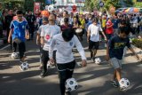 Warga beraksi mendribel bola saat parade Piala Dunia 2018 di 
