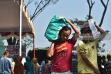 Warga membawa bahan pokok bersubsidi yang dibeli di stand Pasar Murah Ramadan yang digelar Pemkab Madiun di Desa Purworejo, Kecamatan Geger, Kabupaten Madiun, Jawa Timur, Rabu (30/5). Guna meringankan beban masyarakat memenuhi kebutuhan bahan pokok selama Ramadhan dan menghadapi Lebaran, Pemkab Madiun menggelar pasar murah dengan harga bersubsidi. Beras di pasar seharga Rp9.500 dijual Rp6.000, gula di pasar Rp12.500 dijual Rp9.000 dan minyak goreng kemasan di pasar Rp13.000 dijual Rp9.000. Antara Jatim/Siswowidodo/zk/18