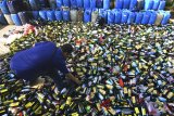 Polisi menunjukan miras oplosan kemasan botol plastik pada pemusnahan barang bukti ribuan botol minuman keras (miras) oplosan di Makopolres Tasikmalaya Kota, Jawa Barat, Selasa (15/5). Pemusnahan barang bukti miras tersebut merupakan hasil operasi Kegiatan Kepolisian Yang Ditingkatkan (KKYD) Polres Tasikmalaya Kota selama satu setengah bulan dengan mumusnahkan 3.542 miras berbagai merk dan 2.784 liter miras tradisional atau oplosan serta 375.306 butir petasan. Pemusnahan tersebut diharapkan dapat menciptakan situasi dan kondisi yang aman dan kondusif jelang Bulan Ramadan 1439 H. ANTARA JABAR/Adeng Bustomi/agr/18