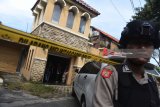 Polisi berjaga saat berlangsung penggeledahan di rumah terduga teroris di kawasan Dukuh Pakis, Surabaya, Jawa Timur, Kamis (17/5). Penggeledahan dalam rangka penyelidikan lanjutan pascapenangkapan terduga teroris di rumah tersebut. Antara Jatim/Zabur Karuru/18