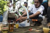 Aktivis lingkungan dari Gerakan Tarik Plastik (Get Plastic) menuangkan bahan bakar minyak jenis premium ke wadah saat pelatihan dan sosialisasi pengolahan sampah plastik di Bandung, Jawa Barat, Senin (21/5). Gerakan Tarik Plastik (Get Plastic) merupakan kampanye peduli sampah plastik di 15 kota menyusuri pulau Jawa dan Bali untuk menggerakan masyarakat agar lebih peduli terhadap lingkungannya terutama terkait sampah plastik. ANTARA JABAR/M Agung Rajasa/agr/18
