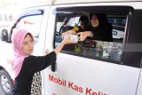 Warga menukar uang rupiah pecahan di mobil kas keliling perbankan di Alun-alun Jember, Jawa Timur, Rabu (30/5). Bank Indonesia Jember menyiapkan uang baru sebanyak Rp7,2 triliun selama Ramadan hingga Lebaran 2018 dan menggandeng delapan perbankan umum untuk melakukan kegiatan kas keliling dengan menyediakan jasa penukaran uang pecahan. Antara Jatim/Seno/zk/18.
