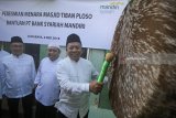 Direktur Financing Risk and Recovery Bank Syariah Mandiri (BSM) Choirul Anwar (kanan) memukul bedug saat peresmian menara Masjid Tiban di Surabaya, Jawa Timur, Minggu (6/5). Pembangunan dan renovasi sarana ibadah tersebut merupakan bagian dari program 