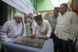 Direktur Financing Risk and Recovery Bank Syariah Mandiri (BSM) Choirul Anwar (tengah) menandatangani prasasti saat peresmian menara Masjid Tiban di Surabaya, Jawa Timur, Minggu (6/5). Pembangunan dan renovasi sarana ibadah tersebut merupakan bagian dari program 