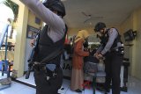 Petugas kepolisian memeriksa warga yang akan masuk ke Mapolres Indramayu, Jawa Barat, Senin (14/5). Petugas memperketat penjagaan kawasan Markas Polres Indramayu pascaledakan bom di sejumlah titik di Surabaya. ANTARA JABAR/Dedhez Anggara/agr/18.