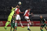 Penjaga gawang Persebaya Surabaya Miswar Saputra (kiri) berusaha menghalau bola dari pesepak bola Persipura Jayapura Hilton Moreira (tengah) dalam lanjutan Liga 1 di Stadion Gelora Bung Tomo, Surabaya, Jawa Timur, Selasa (29/5). Antara jatim/M Risyal Hidayat/zk/18