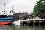 Polisi melakukan penjagaan saat proses penyeberangan bus yang akan digunakan untuk mengangkut tahanan teroris yang akan dipindahkan dari Nusakambangan, di Dermaga Penyeberangan Wijayapura, Cilacap, Jateng, Minggu (20/5/2018). Sejumlah 58 tahanan teroris yang berada di Lapas Batu, Besi dan Pasir Putih di Pulau Nusakambangan, akan dipindahkan ke Lapas Gunung Sindur, Bogor, Jabar, untuk menjalani proses persidangan dan pemeriksaan. (ANTARA FOTO/Idhad Zakaria)