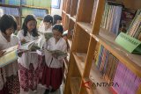 Sejumlah siswi membaca buku di perpustakaan yang telah direvitalisasi saat kegiatan Pijar Ilmu Asuransi Astra di SDN 070 Pasirluyu Bandung, Jawa Barat, Rabu (2/5). Kegiatan sekaligus kampanye sosial pendidikan tersebut di gelar guna memperingati hari Pendidikan Nasional dengan melaksanakan Kelas Inspirasi dan revitalisasi perpustakaan  SDN 070 Pasirluyu yang juga dilaksanakan serentak di 16 cabang Asuransi Astra di tiap kota di Indonesia. ANTARA JABAR/Novrian Arbi/agr/18