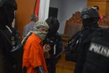 Petugas memborgol tangan terdakwa kasus dugaan serangan teror bom Thamrin dengan terdakwa Oman Rochman alias Aman Abdurrahman seusai menjalani sidang lanjutan di Pengadilan Negeri Jakarta Selatan, Jumat (25/5/2018). Sidang lanjutan tersebut mengagendakan pembacaan pledoi dari terdakwa dan penasehat hukumnya. (ANTARA FOTO/Wahyu Putro A) 