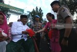 Polisi dan ibu Bhayangkari membagikan takjil kepada warga di Surabaya, Jawa Timur, Senin (21/5). Pembagian takjil kepada warga dan pengguna jalan jelang waktu berbuka puasa itu sebagai bentuk rasa kepeduliannya untuk saling berbagi di bulan Ramadan. Antara Jatim/Didik Suhartono/zk/18