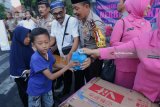 Polisi dan ibu Bhayangkari membagikan takjil kepada warga di Surabaya, Jawa Timur, Senin (21/5). Pembagian takjil kepada warga dan pengguna jalan jelang waktu berbuka puasa itu sebagai bentuk rasa kepeduliannya untuk saling berbagi di bulan Ramadan. Antara Jatim/Didik Suhartono/zk/18