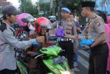 Polisi dan ibu Bhayangkari membagikan takjil kepada warga di Surabaya, Jawa Timur, Senin (21/5). Pembagian takjil kepada warga dan pengguna jalan jelang waktu berbuka puasa itu sebagai bentuk rasa kepeduliannya untuk saling berbagi di bulan Ramadan. Antara Jatim/Didik Suhartono/zk/18