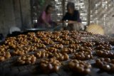 Pekerja membuat jajanan enting-enting atau gula-gula di sebuah indutsri rumahan (UKM) di Gempol, Tulungagung, Jawa Timur, Jumat (25/5). Meningkatnya permintaan sejak awal Ramadhan membuat pelaku UKM setempat menambah volume produksi hingga 120 persen, yakni dari biasanya 30-50 kilogram bahan baku gula merah dan kavang per hari menjadi satu kuintal untuk memenuhi kebutuhan pasar. Antara Jatim/Destyan Sujarwoko/zk/18