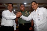 Menteri Pertanian Amran Sulaiman (kiri) bersama Dirut Perum BULOG Budi Waseso (kanan) dan Aster KSAD Mayjen TNI Supartodi (tengah) berjabat tangan usai rapat koordinasi percepatan Serap Gabah Petani di kantor pusat BULOG, Jakarta, Rabu (9/5/2018). Rapat sinergitas antara Perum Bulog, Kementerian Pertanian dan TNI tersebut sebagai upaya optimaslisasi seluruh perangkat pengadaan gabah dan beras untuk mencapai target pengadaan tahun 2018. (ANTARA FOTO/Sigid Kurniawan) 