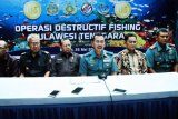 Direktur Operasi Satgas 115 Laksamana Pertama TNI AL Wahyudi Hendro Dwiyono (tengah) memberikan keterangan hasil operasi destructif fishing di Mako Lanal Kendari, Kendari, Sulawesi Tenggara, Jumat (25/5/2018). TNI Angkatan Laut Kendari berhasil mengamankan 25 kilogram ammonium nitrat, 21 botol siap ledak serta satu kaca mata selam dari lima orang nelayan di Kabupaten Konawe yang saat ini diamankan. (ANTARA /Jojon) 