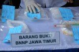 Petugas menunjukkan barang bukti saat ungkap kasus peredaran narkotika di kantor Badan Narkotika Nasional Provinsi (BNNP) Jawa Timur, Surabaya, Jawa Timur, Kamis (24/5). BNNP Jatim menangkap tersangka berinisial AMD atas kasus mengedarkan sabu yang disimpan di dalam mesin penanak nasi elektrik (rice cooker) dan sejumlah barang bukti diamankan beberapa diantaranya Sabu sekitar 2,98 kilogram, tas ransel, penanak nasi elektrik (rice cooker) dan telepon seluler. Antara Jatim/Didik Suhartono/zk/18