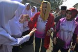 Menteri Badan Usaha Milik Negara (BUMN) Rini Soemarno (tenga) didampingi Plt Direktur Utama PT Pertamina Nicke Widyawat (kanan) bersalaman dengan Santri Pondok Pesantren Darul Arqom pada safari Ramadan di Kabupaten Garut, Jawa Barat, Senin (21/5). Dalam kunjungan Rini Soemarno, meninjau program serapan gabah berbasis kartu tani yang disalurkan oleh BNI, Mitra Desa Bersama (MDB) yang telah memiliki unit bisnis berupa Unit Toko Tani sebagai penyedia kebutuhan sarana produksi, Unit Toko Desa yang menjual kebutuhan harian masyarakat, dan program kredit mikro Mekar yang dijalankan oleh PT PNM, serta bersilaturahmi ke Pondok Pesantren Darul Arqom. ANTARA JABAR/Adeng Bustomi/agr/18  