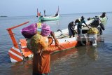 Buruh angkut memikul sembako ke perahu penghubung di Pelabuhan Jangkar, Situbondo, Jawa Timur, Kamis (24/). Penumpang Perahu Layar Motor (PLM) membawa sembako, seperti beras, telur, gula pasir dan minyak goreng untuk kebutuhan puasa hingga hari raya yang dibeli di Situbondo karena harga Sembako di kepulauan Madura berangsur naik. Antara Jatim/Seno/zk/18.