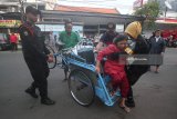 Petugas Perlindungan Masyarakat (Linmas) membantu seorang jemaat turun dari becak di depan Gereja Katolik Santa Maria Tak Bercela di Surabaya, Jawa Timur, Minggu (20/5). Menurut pengurus gereja tersebut sepekan pascaledakan bom, pelaksanaan kebaktian dan misa kembali normal dimulai sejak pagi hingga malam hari. Antara jatim/Moch Asim/zk/18