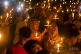 Warga dari berbagai komunitas menyalakan lilin saat doa bersama di Tugu Perjuangan, Indramayu, Jawa Barat, Selasa (15/5). Doa bersama tersebut sebagai bentuk keprihatinan terhadap korban peristiwa serangan terorisme di sejumlah tempat di Surabaya, sekaligus mendoakan keamanan, persatuan dan kesatuan antarwarga Indonesia. ANTARA JABAR/Dedhez Anggara/agr/18.