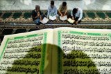 Umat muslim membaca Alquran di Masjid Syuhada Lhokseumawe, Aceh, Jumat (18/5/2018) dini hari. Setiap memasuki Ramadan, umat muslim mulai memperbanyak ibadah dengan membaca Alquran, berzikir (itikaf) di dalam masjid memohon ampunan Allah SWT. (ANTARA /Rahmad) 