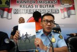 Kepala Kantor Imigrasi Blitar Muhammad Akram menunjukkan barang bukti berupa foto saat rilis di Kantor Imigrasi Kelas II Blitar, Jawa Timur, Senin (7/5). Tim Pengawasan Orang Asing (TIMPORA) Kanim Blitar berhasil mengamankan seorang pesepakbola asing asal Pantai Gading bernama Konan N'Zue Ange Olivier berusia 24 tahun saat sedang bermain bola, karena tidak memiliki paspor dan surat ijin keimigrasian yang sah (Ilegal).Antara Jatim/Irfan Anshori/zk/18