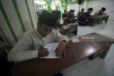 Santri memaknai kitab Tafsir saat mengikuti pengajian kitab di Pondok Pesantren Tahfidhul Quran Sunan Giri, Surabaya, Jawa Timur, Rabu (23/5). Pengajian kitab-kitab salaf tersebut merupakan tradisi di pondok pesantren sebagai bekal dan menambah wawasan keagamaan bagi para santri. Antara Jatim/Moch Asim/zk/18