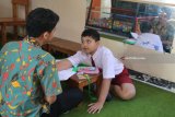 Seorang siswa tuna ganda mengikuti Ujian Sekolah Berstandar Nasional (USBN) didampingi seorang guru di ruangan khusus SD Inklusi Betet I, Kota Kediri, Jawa Timur, Kamis (3/5). USBN yang wajib diikuti oleh siwa reguler dan juga siswa berkebutuhan khusus tersebut sebagai syarat tamat belajar. Antara Jatim/Prasetia Fauzani/mas/18