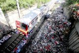 Kereta melintas disamping tumpukan sampah di pinggir rel kereta di Gunung Putri, Bogor, Jawa Barat, Jumat (11/5). Kementerian Lingkungan Hidup dan Kehutanan (KLHK) menyatakan proyeksi volume sampah rumah tangga pada 2018 mencapai 66,5 juta ton dan Pemerintah menargetkan pengurangan sampah rumah tangga serta sampah sejenis pada 2018 mencapai 15 persen hingga 2025 targetnya 30 persen. ANTARA JABAR/Yulius Satria Wijaya/agr/18.
