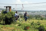 Wisatawan saat menikmati liburan menaiki sepeda wisata di Gunung Pancar, Bogor, Jawa Barat, Kamis (10/5). Sebagai salah satu wisata alam yang yang menyajikan pemandangan alami hutan pinus, Gunung Pancar merupakan salah satu destinasi untuk kegiatan alam seperti camping, bersepeda, jogging, dan hiking oleh masyarakat dalam memanfaatkan momen liburan kenaikan Isa Almasih. ANTARA JABAR/Yulius Satria Wijaya/agr/18.
