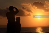 Wisatawan foto dengan latar belakang matahari terbit di Pantai Boom, Banyuwangi, Jawa Timur, Jumat (11/5). Kabupaten Banyuwangi yang memiliki julukan Sunrise of Java tersebut, menjadi tujuan wisatawan untuk menikmati suasana matahari terbit pertama di pulau Jawa. Antara Jatim/Budi Candra Setya/mas/18.