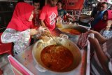 Pedagang musiman menjajakan masakan tradisional untuk menu berbuka puasa di Lambaro, Aceh Besar, Aceh, Selasa (22/5). Lauk dengan masakan tradisional seperti kuah beulangong (kari sapi), sie manok (kari ayam), sie itek (kari bebek) dan kuah ikan paya (kari ikan air tawar) menjadi menu favorit bagi warga setempatselama bulan Ramadan. (ANTARA FOTO/Irwansyah Putra/kye/18)