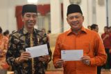 Presiden Joko Widodo (kiri) bersama Ketua DPR Bambang Soesetyo memperlihatkan tanda terima pembayaran zakat seusai membayar zakat di Istana Negara, Jakarta, Senin (28/5). Presiden bersama sekitar 300 pejabat kementerian / lembaga tinggi negara dan direksi BUMN melakukan pembayaran zakat melalui Baznas . ANTARA FOTO/Wahyu Putro A/pd/18