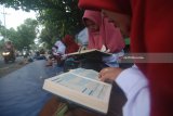 Mahasiswa mengaji bersama di trotoar Jalan Doktor Soetomo, Jombang, Jawa Timur, Rabu (16/5). Kegiatan mengaji Alquran on the street yang diadakan KAMMI (Kesatuan Aksi Mahasiswa Muslim Indonesia) Jombang tersebut, untuk menyambut datangnya bulan suci Ramadan. Antara Jatim/Syaiful Arif/zk/18