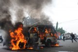 Seorang jurnalis mengambil gambar angkutan kota (angkot) yang terbakar di Cikokol, Tangerang, Banten, Kamis (17/5). Kebakaran angkot tersebut disebabkan karena arus pendek pada kelistrikannya dan tidak ada korban jiwa dalam peristiwa tersebut. ANTARA FOTO/Muhammad Iqbal/aww/18.