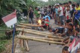 Sejumlah warga menghabiskan waktu menunggu berbuka puasa (ngabuburit) dengan mengikuti lomba 'mercon zlung' di Desa Wuled, Kabupaten Pekalongan, Jawa Tengah, Jumat (25/5). Lomba mercon zlung yang menggunakan bahan bambu dengan minyak tanah yang disulut dengan api yang dapat menghasilkan suara ledakan dari lubang bambu tersebut bertujuan untuk menjalin kekompakan pemuda setempat. ANTARA FOTO/Harviyan Perdana Putra/aww/18.