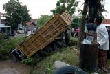 Warga memperhatikan truk yang masuk ke sungai di Jalur Tengah Tegal-Purwokerto, Desa Setol, Kabupaten Tegal, Jawa Tengah, Jumat (18/5). Tabrakan antara truk pengangkut material galian C dan mobil boks yang diduga rem blong tersebut mengakibatkan dua korban luka-luka. ANTARA FOTO/Oky Lukmansyah/kye/18