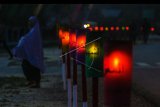 Umat muslim berjalan di dekat lampu colok bertuliskan 99 Asmaul Husna di Pekanbaru, Riau, Kamis (24/5). Lampu colok ini dibuat pengurus masjid untuk memeriahkan suasana bulan suci Ramadan. ANTARA FOTO/Rony Muharrman/kye/18