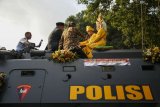 Pasangan pengantin mengikuti nikah bareng di atas mobil panser di kawasan Malioboro, DI Yogyakarta, Senin (14/5). Acara Nikah Bareng dengan mahar seperangkat alat salat, bendera merah putih dan membaca teks Pancasila itu diikuti 11 pasangan pengantin untuk membantu masyarakat kurang mampu agar mendapat legalitas pernikahan. ANTARA FOTO/Hendra Nurdiyansyah/aww/18.