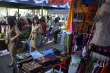 Warga melihat pakaian adat khas Bali saat pasar murah menjelang Hari Raya Galungan di Taman Lumintang Kota Denpasar, Selasa (22/5). Pasar murah tersebut merupakan produk lokal keperluan menyambut Hari Raya Galungan yang dijual lebih murah dibanding harga pasaran sebagai upaya pemerintah menekan inflasi di Kota Denpasar. ANTARA FOTO/Wira Suryantala/wdy/2018.