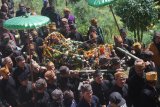 Warga suku Tengger mengarak sesaji berupa kepala kerbau dan tumpeng dalam tradisi Ritual Unan-Unan di lereng Gunung Bromo di Desa Ngadas, Malang, Jawa Timur, Kamis (31/5). Tradisi Ritual Unan-unan yang diadakan lima tahun sekali dalam perhitungan kalender Tengger tersebut merupakan bentuk ungkapan syukur terhadap Tuhan Yang Maha Esa sekaligus permohonan agar diberi keselamatan dan terhindar dari bencana. ANTARA FOTO/Ari Bowo Sucipto/wdy/2018.