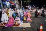 Sejumlah warga melaksanakan salat tarawih di pinggir jalan Mushola Miftahul Jannah di Kawasan Pasar Gembrong, Jakarta, Kamis (17/5). Warga antusias melaksanakan salat tarawih pada awal bulan suci Ramadan yang mengakibatkan masjid dipenuhi jemaah sampai ke badan jalan dan jembatan penyeberangan orang. ANTARA FOTO/Rivan Awal Lingga/ama/18