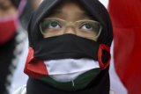 Pengunjuk rasa mengenakan masker berwarna bendera Palestina saat mengikuti aksi di depan Kedutaan Besar Amerika Serikat, Jakarta, Jumat (8/6/2018). Pada aksi unjuk rasa dalam rangka memperingati Hari Al Quds Internasional itu massa menuntut kemerdekaan rakyat Palestina dan mengecam keberpihakan Amerika Serikat kepada Israel atas pendudukan di Palestina. (ANTARA /Hafidz Mubarak A) 